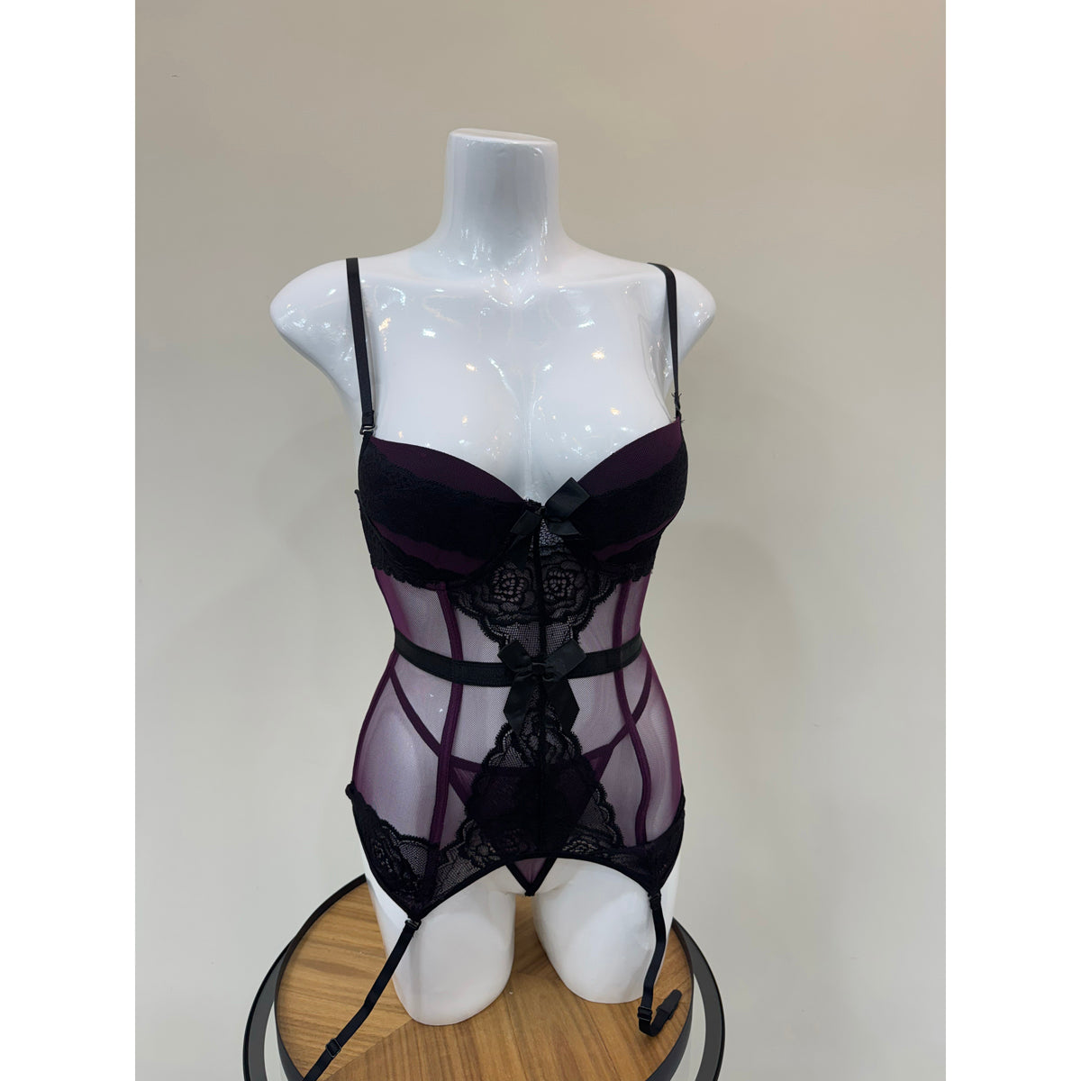 Black lace lingerie on a mannequin against a plain background
